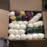 a box of white, gre, red and yellow yarn